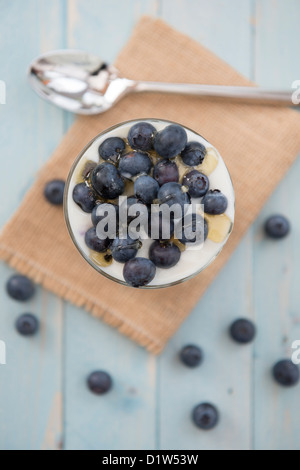 Blueberries in natural yoghurt with drizzled honey, dessert or snack. Presented in a glass tumbler. Stock Photo