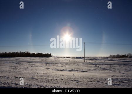 pair of sun dog parhelion halo due to ice crystals surrounding the sun in Saskatchewan Canada Stock Photo