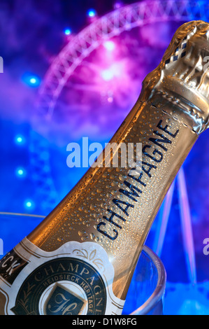 Bottle of champagne on ice in wine cooler with London Eye behind at night with big celebration party fireworks Stock Photo