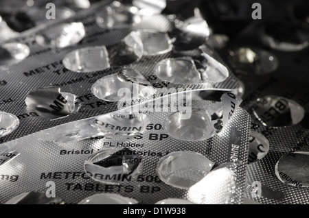 used empty open medical blister packets of metformin 500mg tablets pill almost black and white silvery aluminum for diabetes Stock Photo