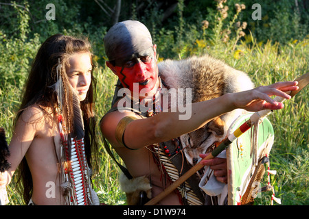 A Native American Indian man pointing to the distance showing his son where to hunt Stock Photo