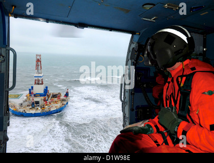 Rear Adm. Thomas Ostebo, commander, 17th Coast Guard District and D17 Incident Management Team commander, conducts an aerial view of the mobile drilling unit Kulluk January 1, 2013 near Sitkalidak Island, Alaska. The Kulluk was floating free after the ship towing it lost power and its tow connection in the Kodiak archipelago. Stock Photo