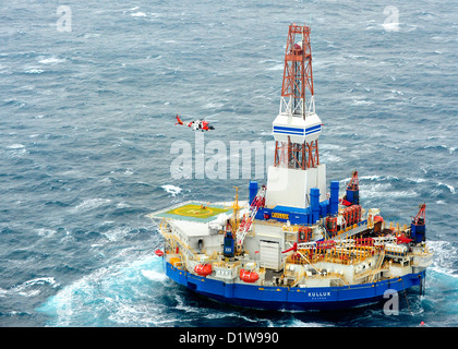 A US Coast Guard MH-60 Jayhawk helicopter lifts the first six of 18 crewmen from the mobile drilling unit Kulluk December 29, 2012, 80 miles southwest of Kodiak City, Alaska. The Kulluk was floating free after the ship towing it lost power and its tow connection in the Kodiak archipelago. Stock Photo