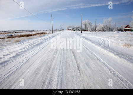 snow covered road in small rural farming community village Forget Saskatchewan Canada Stock Photo