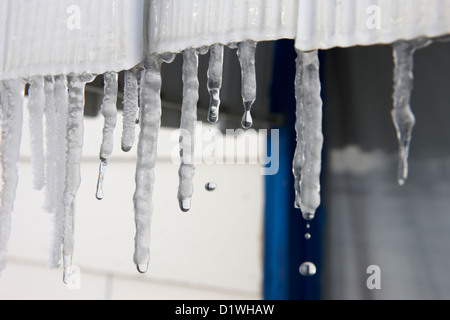 water dripping from icicles on a house melting in sunshine in Forget Saskatchewan Canada Stock Photo