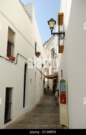 A man walks down cobbled streets in Vejer de la Frontera, one of the Pueblos Blancos or White Towns of Andalusia, Spain Stock Photo