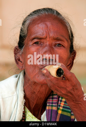 Portrait of a local Burmese woman smoking a large cheroot at a market near Bagan, (Pagan), Burma, (Myanmar), Southeast Asia. Stock Photo