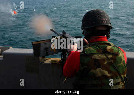 (Jan. 7, 2013)   - Aviation Ordnanceman Airman Zachary Andrews fires a .50-caliber machine gun during a crew serve weapons shoot aboard the aircraft carrier USS John C. Stennis (CVN 74). John C. Stennis is deployed to the U.S. 5th Fleet area of responsibility conducting maritime security operations, theater security cooperation efforts and support missions for Operation Enduring Freedom. (U.S. Navy photo by Mass Communication Specialist 2nd Class Kenneth Abbate/Released) Stock Photo