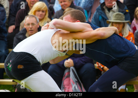 Cumberland & Westmorland Wrestlers in clinch, with crowd behind at Grasmere Lakeland Sports,Lake District National Park,Cumbria, Stock Photo