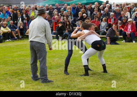 Cumberland & Westmorland Wrestlers in clinch, with crowd behind at Grasmere Lakeland Sports,Lake District National Park,Cumbria, Stock Photo