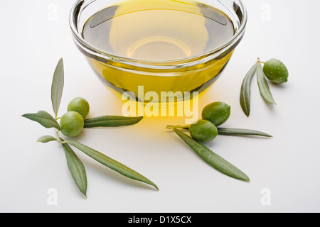 extra virgin olive oil with green olives and leaves isolated on white ...