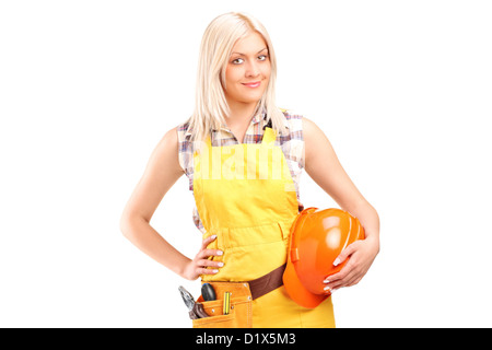 A smiling female worker with a tool belt holding helmet isolated on white background Stock Photo