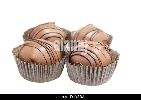 Group of four milk chocolate truffles bon bon with dark chocolate swirls isolated on white background Stock Photo