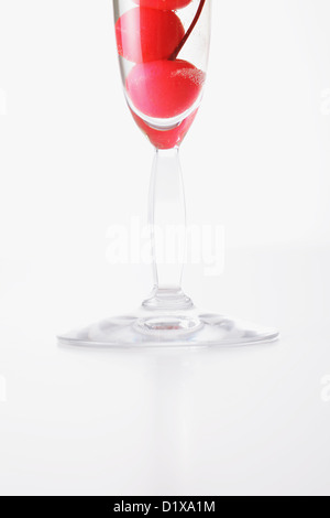 Glass of Champagne full of cherries Stock Photo