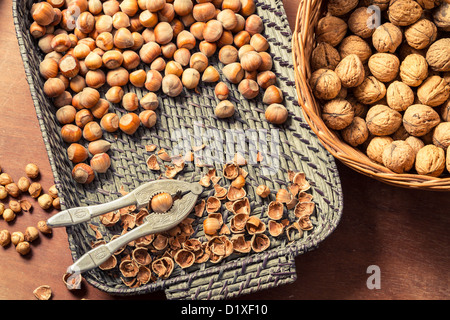 Different kinds of nuts in wicker baskets on old table Stock Photo