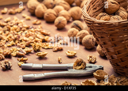 Closeup of cracking walnuts on wicker basket Stock Photo