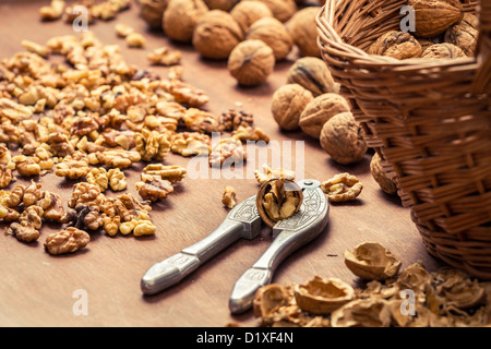 Cracking walnuts on wicker basket Stock Photo