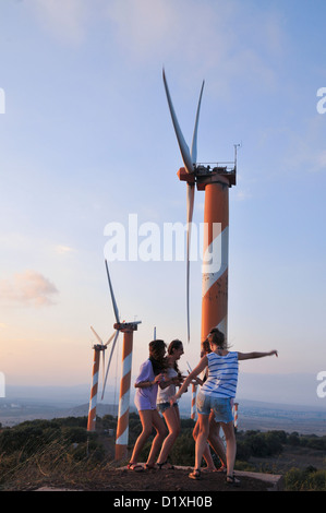 Excited young girls stand near Wind turbines. Photographed in Israel, Golan Heights, near kibbutz Ein Zivan, Stock Photo