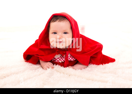 Baby Little Red Riding Hood on white fur with funny expression Stock Photo