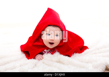 Baby Little Red Riding Hood on white fur with funny expression Stock Photo