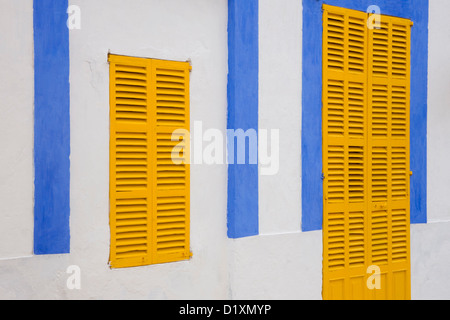 Portocolom, Mallorca, Balearic Islands, Spain. Façade of blue and white house with yellow shutters in the old town. Stock Photo