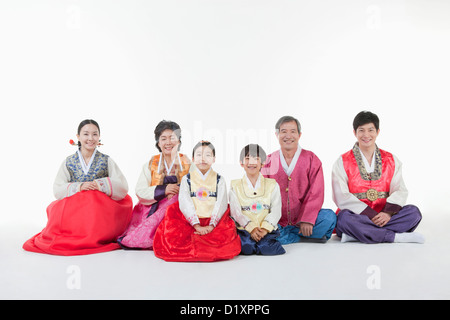 a big family sitting on the floor wearing Hanbok Stock Photo