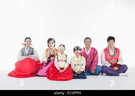 a big family sitting on the floor wearing Hanbok Stock Photo