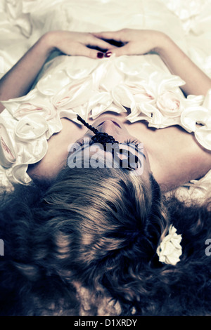 a woman in a white wedding dress with a scorpion on her forehead Stock Photo