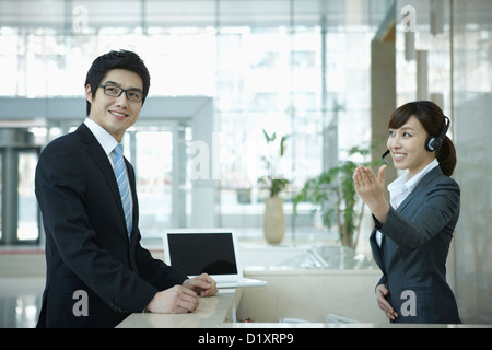 a businessman and help desk woman smiling at camera Stock Photo