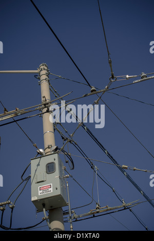 Overhead street car power cables against a blue sky Stock Photo