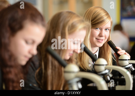 School girls using microscopes during a science lesson at Pates Grammar School in Cheltenham, Gloucestershire UK Stock Photo