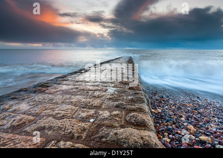 Waves rushing over the breakwater alongside beach in Dawlish, Devon, England, United Kingdom, Europe. Stock Photo