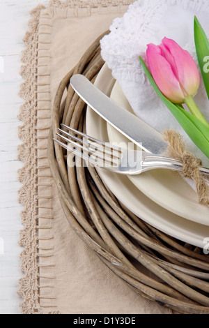 Rustic dinner setting with pink tulip on white wooden table Stock Photo