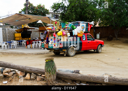 A truck selling cleaning supplies is parked while the owner buys lunch at a taco stand in Todos Santos, Baja, Mexico Stock Photo