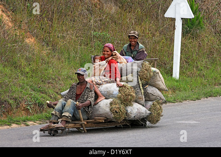 Local home-made transport on the way to market along the highway used by huge wagons Stock Photo