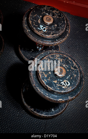 An old but well used set of dumbbells at the gym. Stock Photo