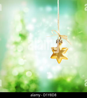 Christmas star ornament over green tree lights background Stock Photo