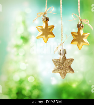 Christmas star ornaments over green tree lights background Stock Photo