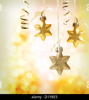 Christmas star ornaments over yellow orange lights background Stock Photo