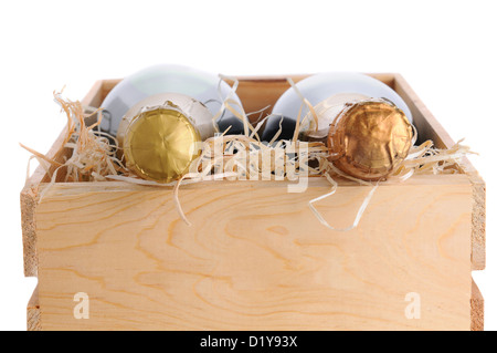 End view of two champagne bottles in a wood crate with packing material. Horizontal format closeup isolated on white. Stock Photo
