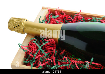 Closeup of a Champagne bottle in a wood shipping crate with shredded filler paper in Christmas Holiday colors. Stock Photo