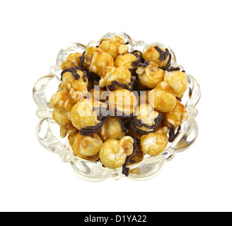 A small leaded glass bowl filled with caramel popcorn with chocolate sprinkles on a white background. Stock Photo