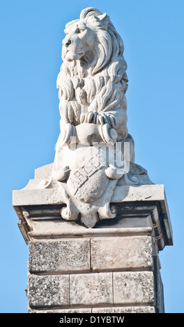 A majestic stone Lion sculpture sitting upon a block pillar in the town of Arles, Southern France. Stock Photo