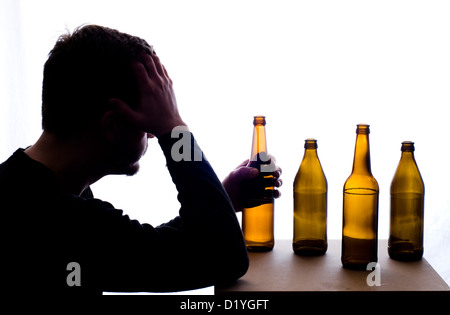 Silhouette of a man with a beer bottle. Strong contrast, cold blueish glow. Isolated on a white background. Stock Photo