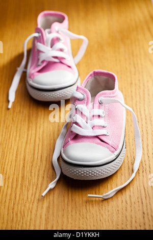 Pink trainers on wooden background. Graphic resources Stock Photo - Alamy