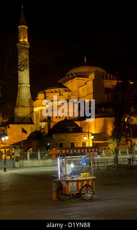 Street vendor selling corn on the cob and other snacks at night outside Aya Sofya in Istanbul Turkey Stock Photo