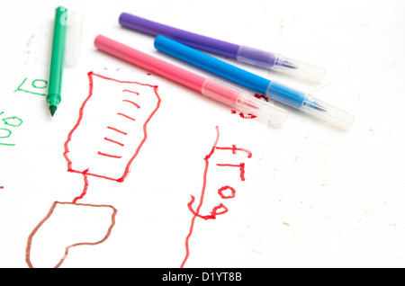 Young child's drawing and writing on white paper with color pens Stock Photo