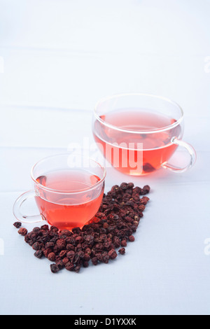 two cups of omija tea and fruit of Maximowiczia typica Stock Photo