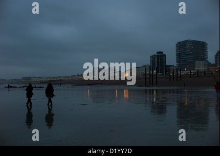 People walking on the beach, low tide, brighton, evening Stock Photo