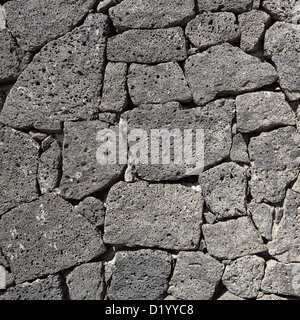 Texture of the black volcanic rock wall from Lanzarote, Canary Islands, Spain. Stock Photo
